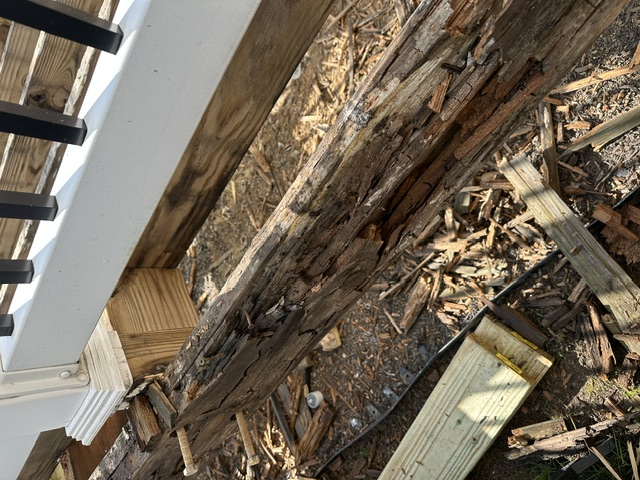 Rotted deck ledger and timber being removed